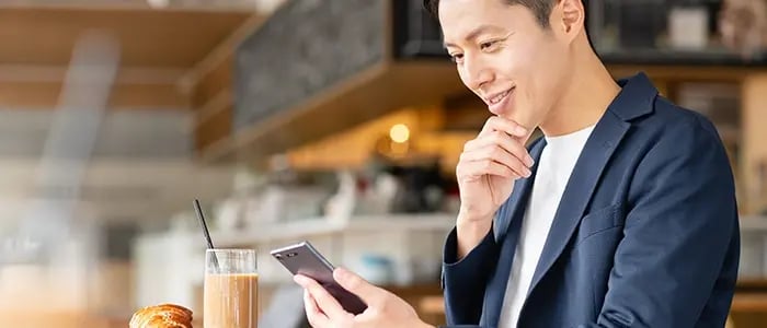 カフェでSNSを閲覧する男性